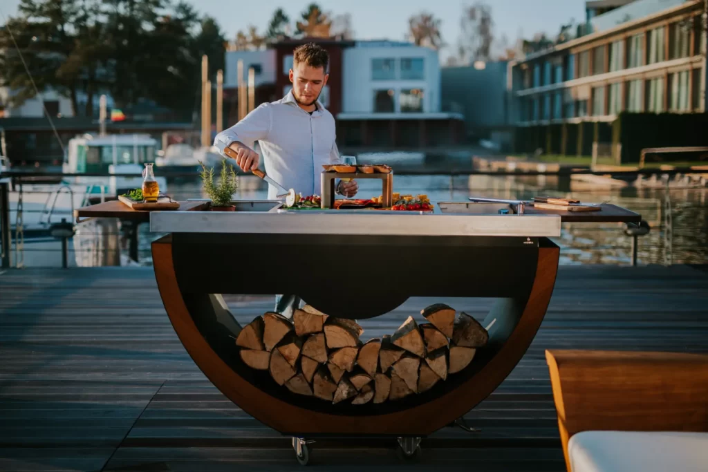 Outdoor live cooking kitchen with steel, wood fabrication, and powder-coated finish.